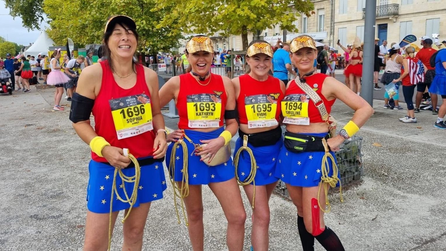 Fiona and her 3 friends in super woman costumes posing for camera at the marathon in France