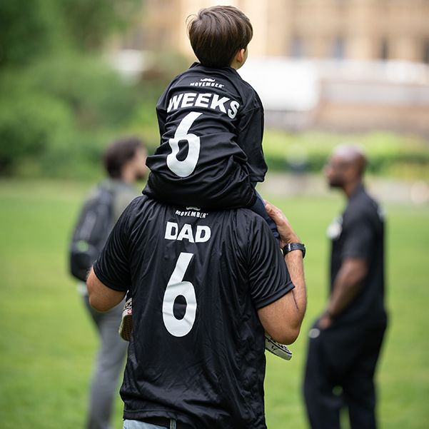 Photo of a dad with a child on his shoulders.
