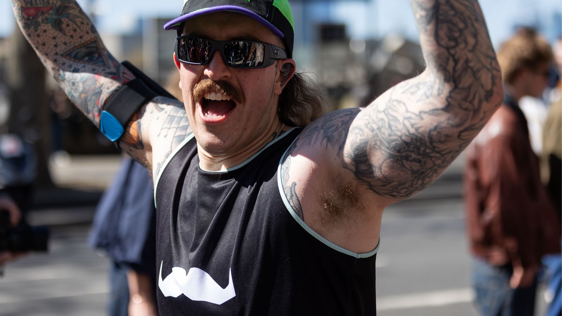 Athletic young man participating in a marathon, smiling and cheering.