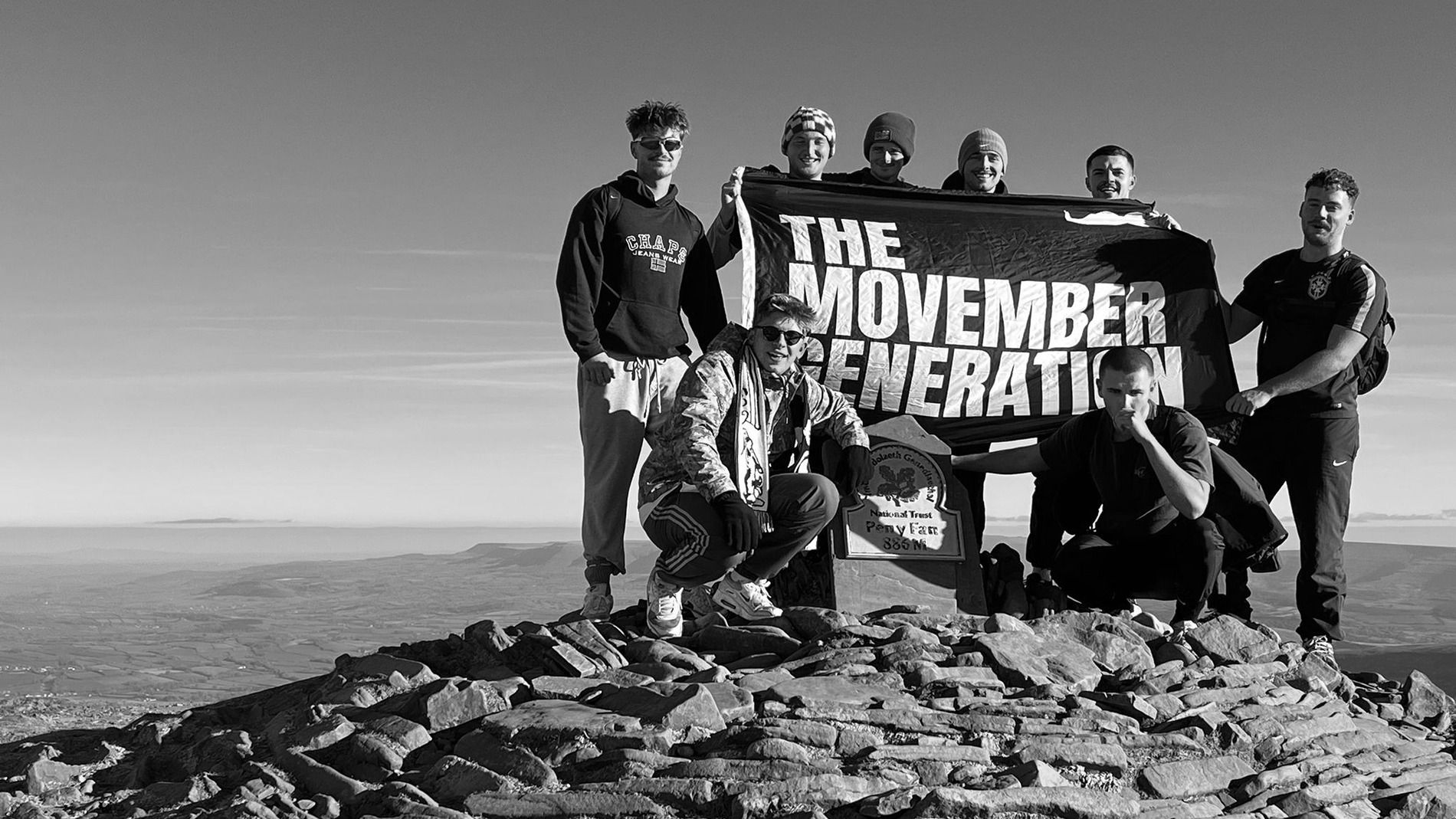Students at the top of Pen-y-fam with Movember flag