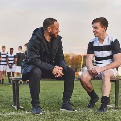Rugby coach talking to young player about mental health as part of Movember's Ahead of the Game programme.