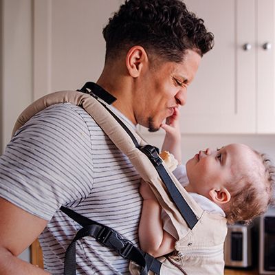 Photo of a dad with an infant in his chest sling.