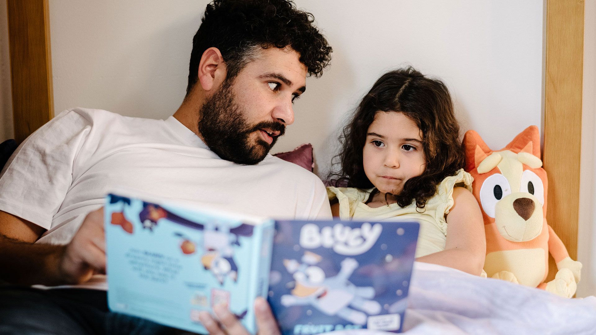 A father reading their child a bed time story