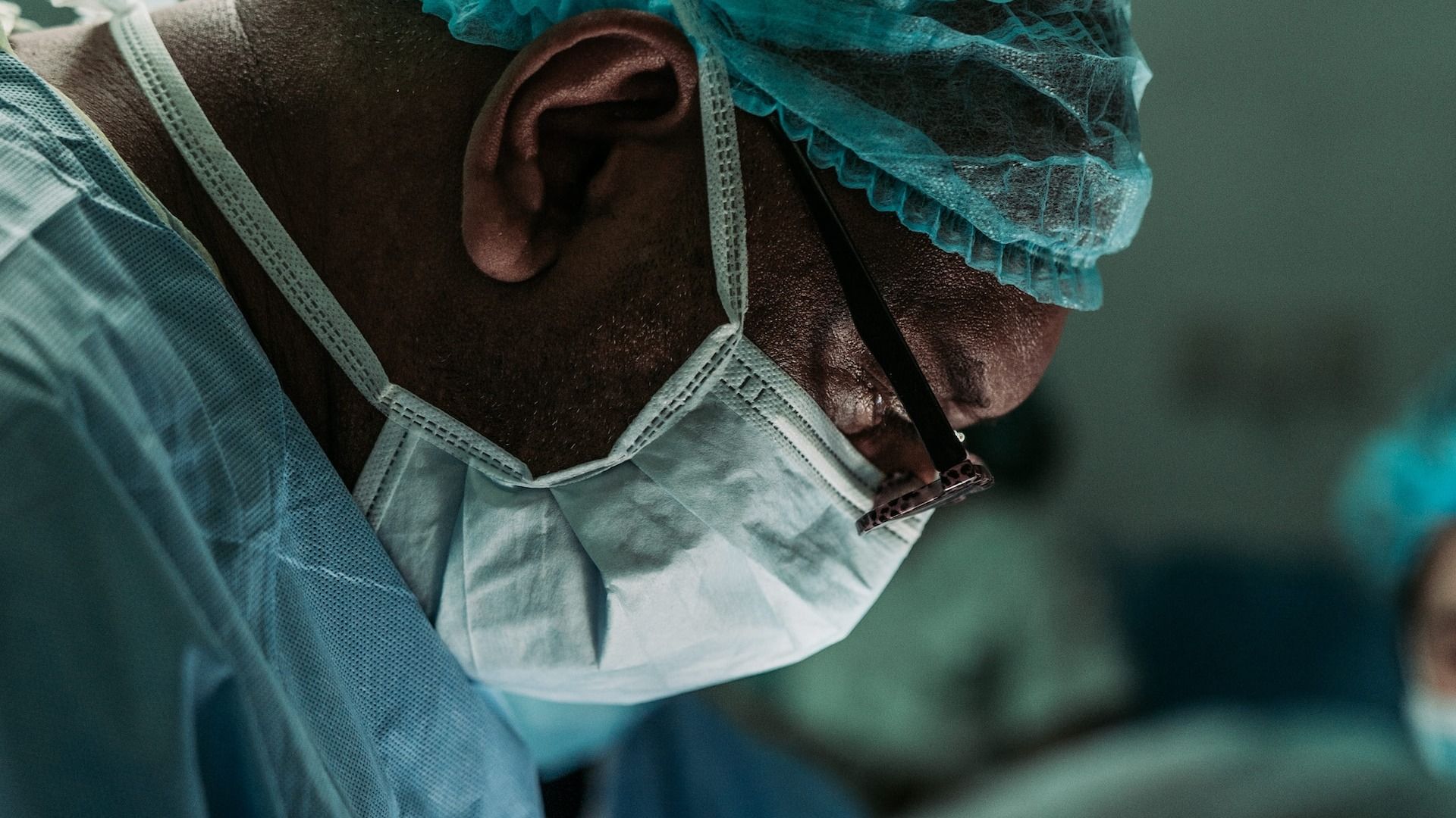 Side view photo of a medical professional in full surgical attire.