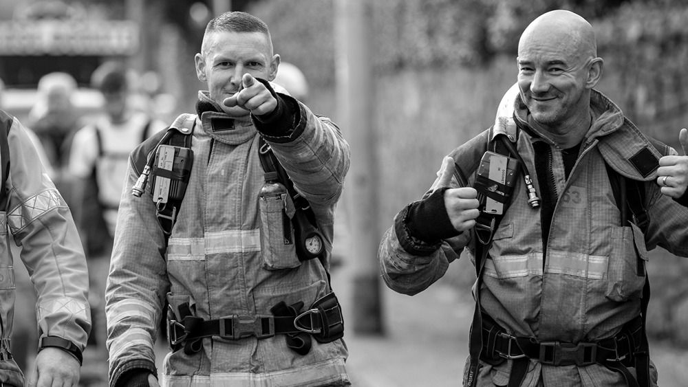 2 firefighters in uniform smiling at camera