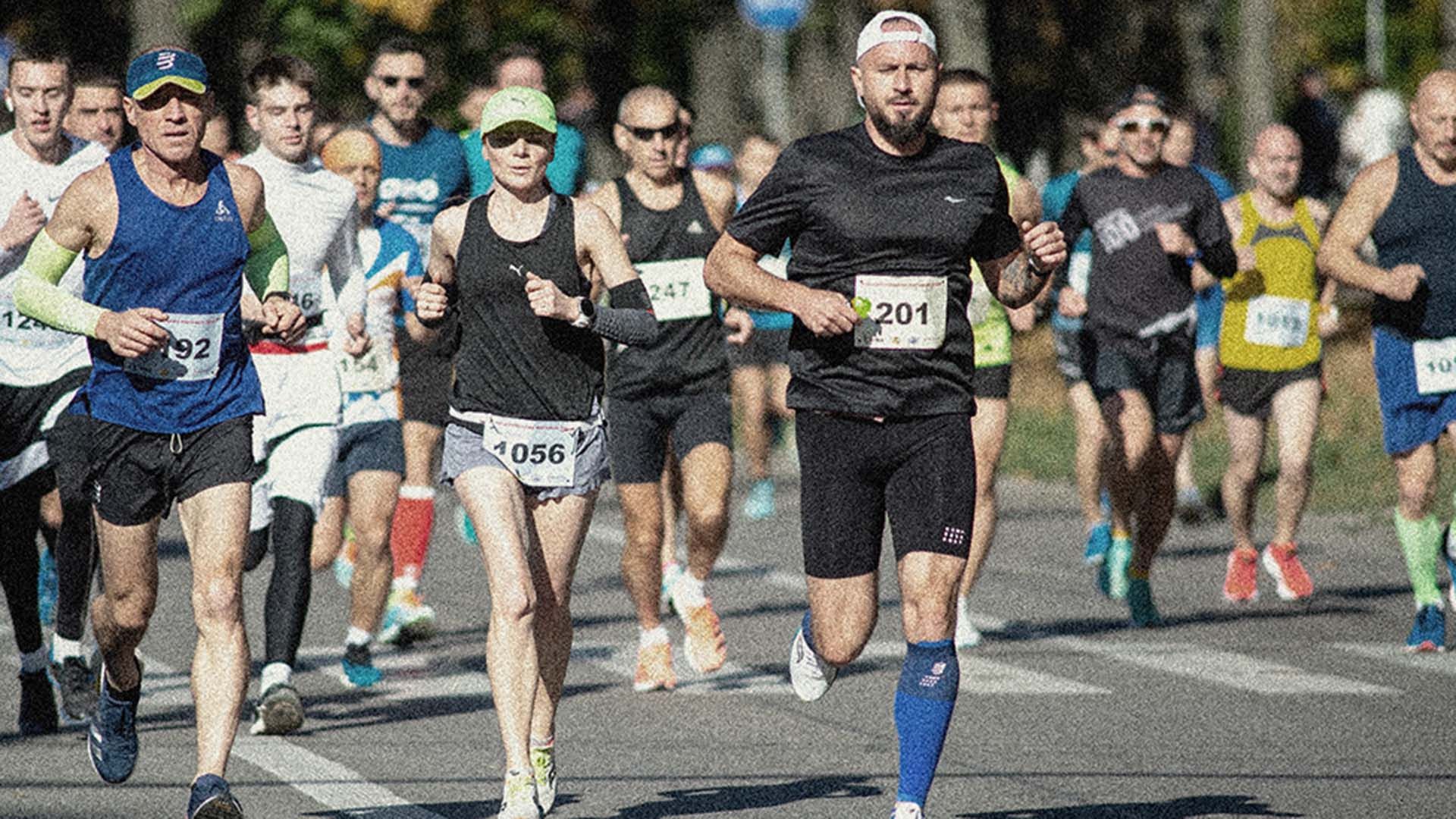 Photo focussed on marathon runner, running at a race.